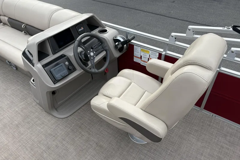 Slide: The Image of 2024 Sun Tracker Party Barge 20 DLX helm with beige captain's chair and control panel. - 17