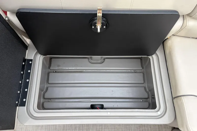 Slide: The Image of 2024 Sun Tracker Party Barge 20 DLX storage compartment with open lid. - 20