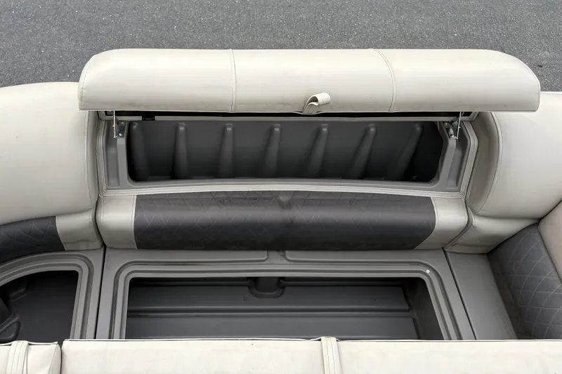 Slide: The Image of 2024 Sun Tracker Party Barge 20 DLX storage compartment with open seat cushion. - 25