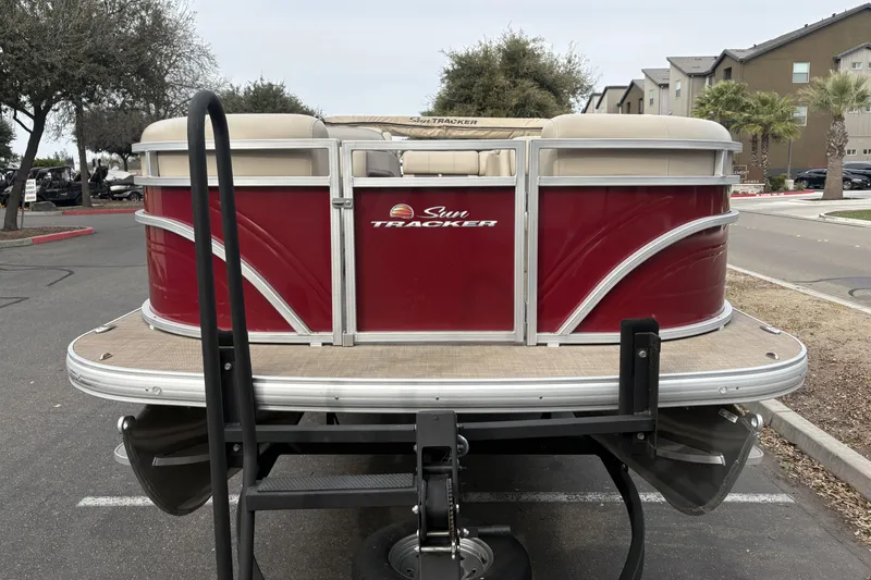 Slide: The Image of 2024 Sun Tracker Party Barge 20 DLX pontoon boat, red exterior, parked outdoors. - 6