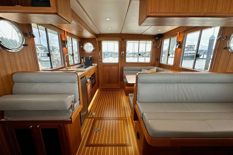 Slide: The Image of Luxurious 2022 Helmsman Trawlers 37 Sedan interior with wood finish and modern seating. - 6
