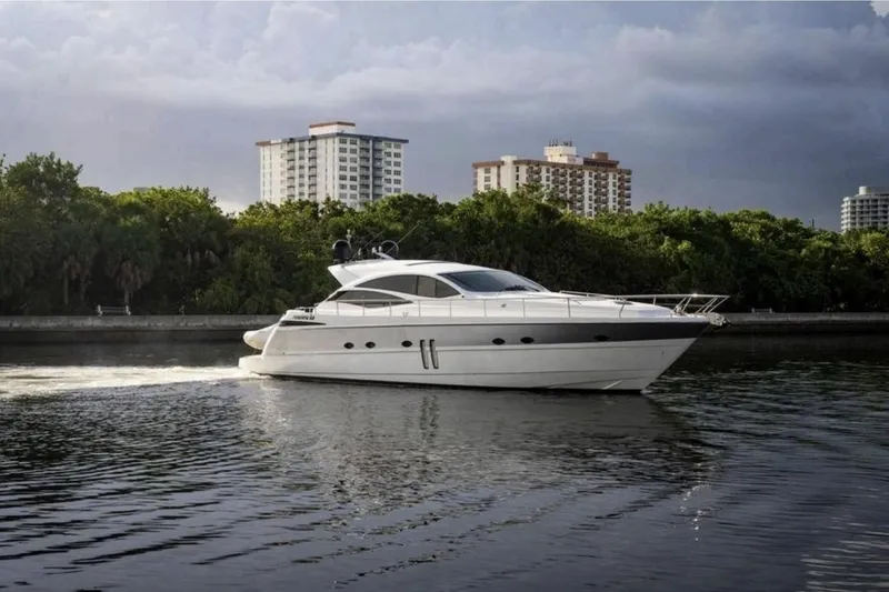 The Image of 2007 Pershing 62' yacht cruising on a calm river with cityscape backdrop. - 0