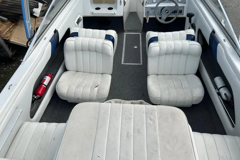Slide: The Image of 1995 Reinell 18 BRXL boat interior with white seating and fire extinguishers. - 10