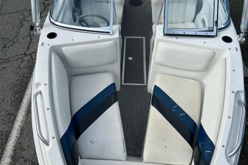 Slide: The Image of 1995 Reinell 18 BRXL boat interior with white and blue seating, open windshield, and carpeted floor. - 12