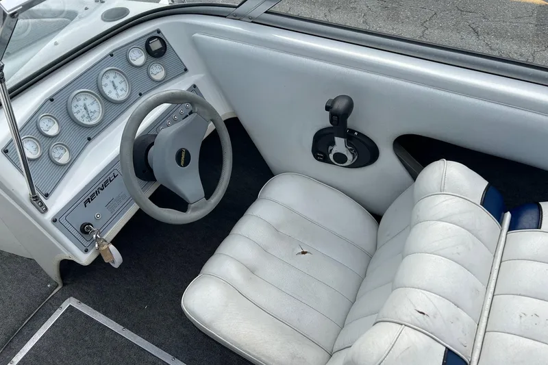 Slide: The Image of 1995 Reinell 18 BRXL boat interior with steering wheel and dashboard gauges. - 6