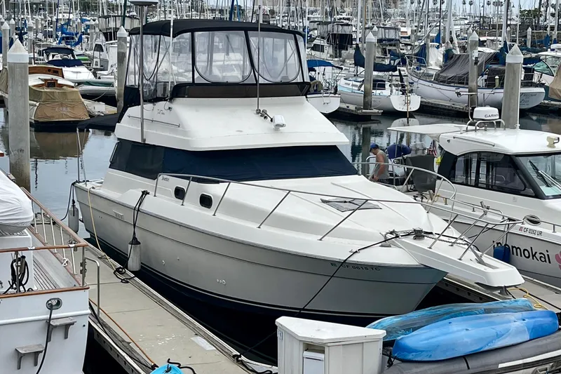 The Image of 1989 Silverton 34 Convertible yacht docked in a marina with other boats. - 0