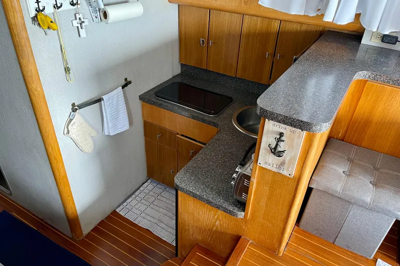 Slide: The Image of 1989 Silverton 34 Convertible yacht kitchen with wooden cabinets and compact design. - 10