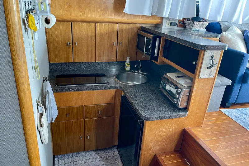 Slide: The Image of 1989 Silverton 34 Convertible yacht kitchen with wood cabinets and modern appliances. - 11