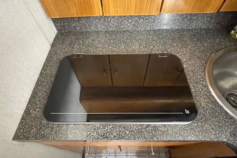 Slide: The Image of Granite countertop with a closed black stove cover on a 1989 Silverton 34 Convertible. - 12