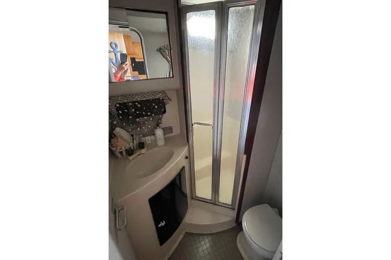 Slide: The Image of 1989 Silverton 34 Convertible bathroom with shower, sink, and mirror. - 16