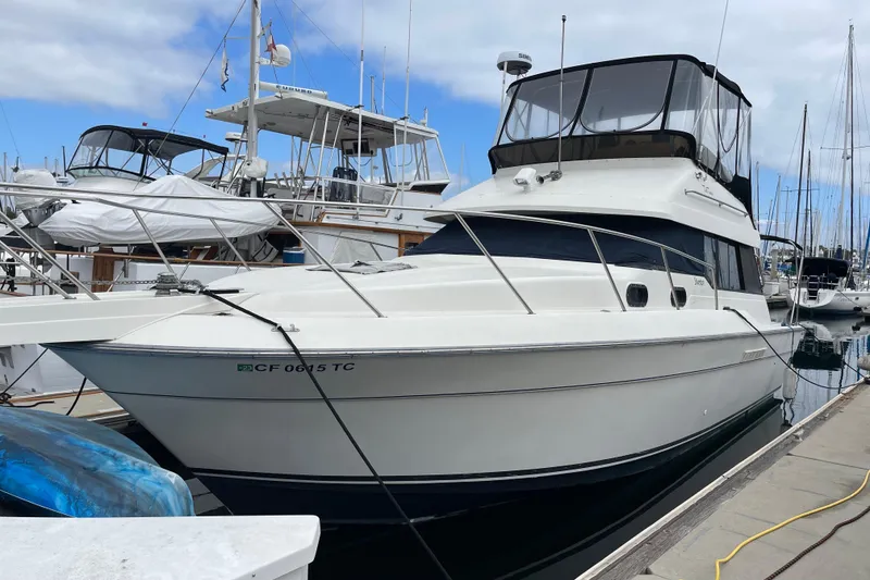 Slide: The Image of 1989 Silverton 34 Convertible yacht docked at marina under cloudy sky. - 2