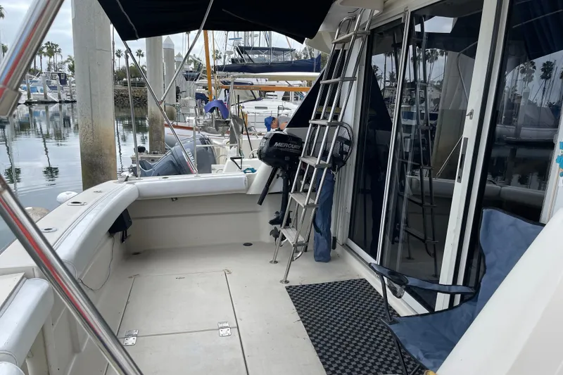 Slide: The Image of 1989 Silverton 34 Convertible yacht docked at marina, featuring spacious deck and seating. - 3