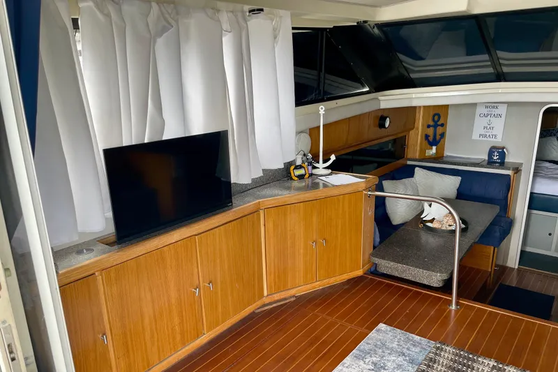 Slide: The Image of 1989 Silverton 34 Convertible yacht interior with TV, wooden cabinets, and nautical decor. - 8