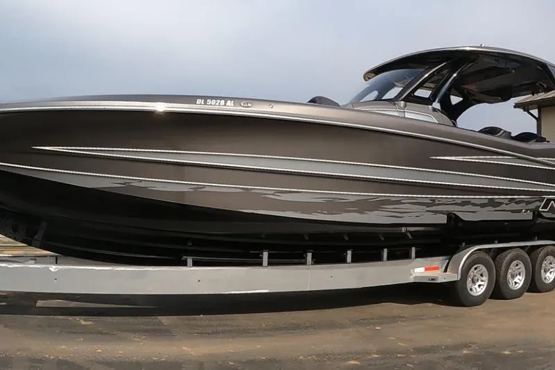 The Image of 2018 MTI V42 boat on trailer, sleek design, triple-axle, ready for transport. - 0