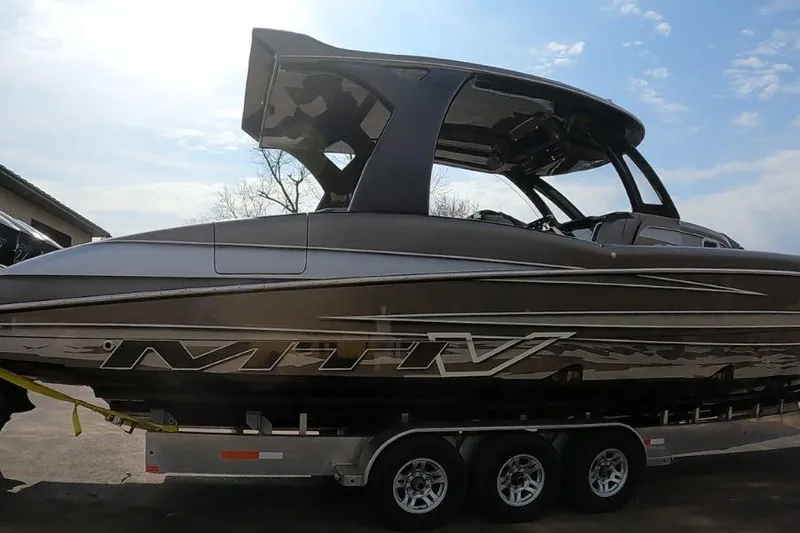 Slide: The Image of 2018 MTI V42 boat on trailer under a clear sky. - 2