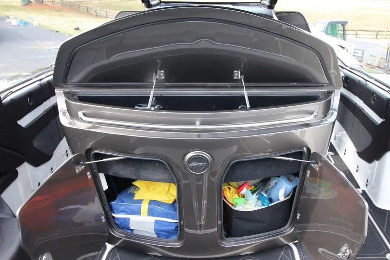 Slide: The Image of Open storage compartments on a 2018 MTI V42 boat, containing various items. - 28