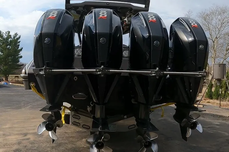 Slide: The Image of Four powerful outboard motors on a 2018 MTI V42 boat, parked outdoors. - 4
