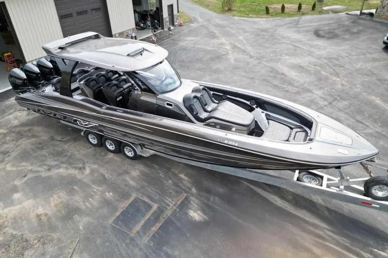 Slide: The Image of 2018 MTI V42 boat on trailer, sleek design, multiple outboard engines, parked near garage. - 6