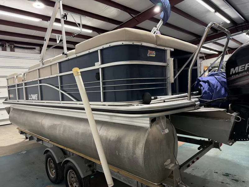 Slide: The Image of 2014 Lowe SS 210 pontoon boat in warehouse on trailer. - 19