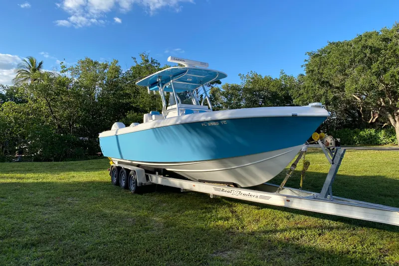 Slide: The Image of 2022 Bluewater 2850 CC boat on trailer, parked on grass under clear blue sky. - 29
