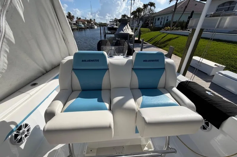 Slide: The Image of 2022 Bluewater 2850 CC boat with open livewell, docked by a canal. - 3