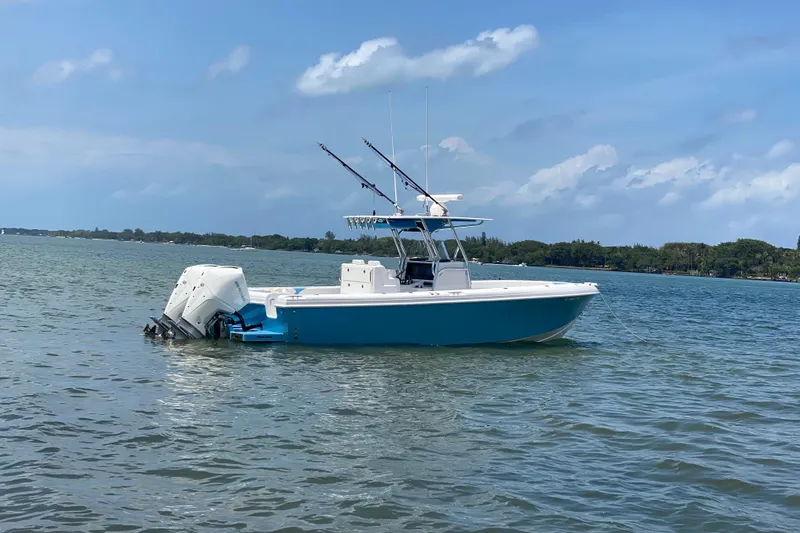 Slide: The Image of 2022 Bluewater 2850 CC boat on calm water under a clear blue sky. - 31