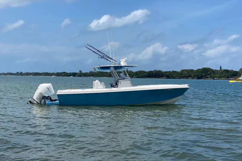 Slide: The Image of 2022 Bluewater 2850 CC boat anchored on calm water under a clear blue sky. - 32