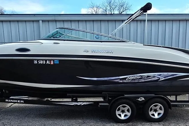 The Image of 2006 Rinker 246 Captiva Cuddy boat on trailer, side view. - 0