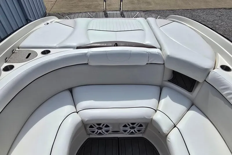 Slide: The Image of 2006 Rinker 246 Captiva Cuddy boat interior with white cushioned seating and cup holders. - 13