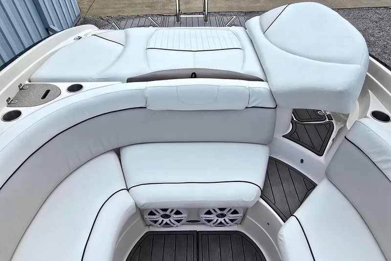 Slide: The Image of 2006 Rinker 246 Captiva Cuddy boat interior with white cushioned seating and cup holders. - 14