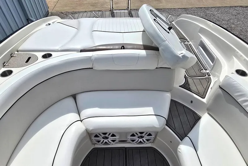 Slide: The Image of 2006 Rinker 246 Captiva Cuddy boat interior with white cushioned seating and cup holders. - 15