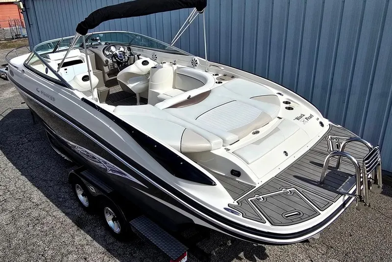 Slide: The Image of 2006 Rinker 246 Captiva Cuddy boat with sleek design and spacious seating. - 2