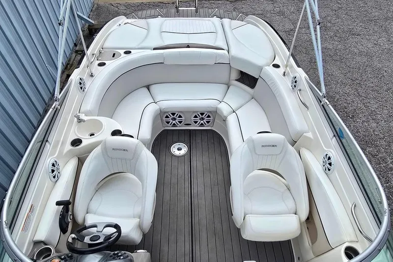 Slide: The Image of 2006 Rinker 246 Captiva Cuddy boat interior with white seating and wood flooring. - 4