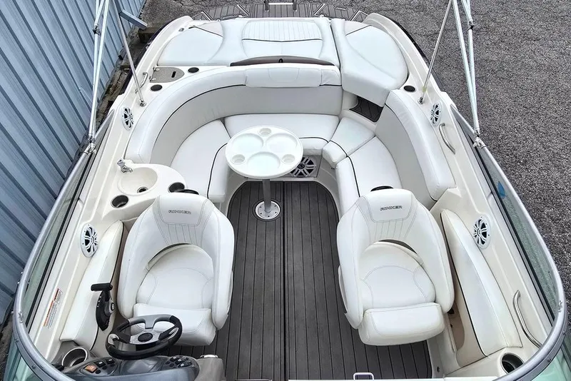 Slide: The Image of 2006 Rinker 246 Captiva Cuddy boat interior with white seating and table. - 5
