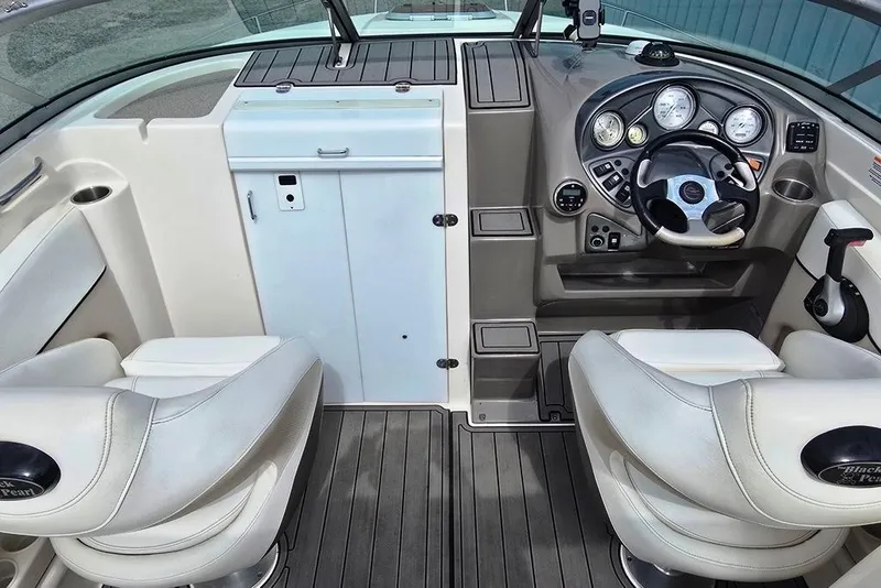 Slide: The Image of Interior of a 2006 Rinker 246 Captiva Cuddy boat with steering wheel and seating. - 6