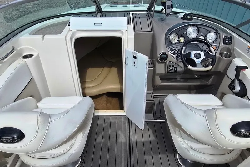 Slide: The Image of 2006 Rinker 246 Captiva Cuddy interior with steering wheel and cabin entrance. - 7