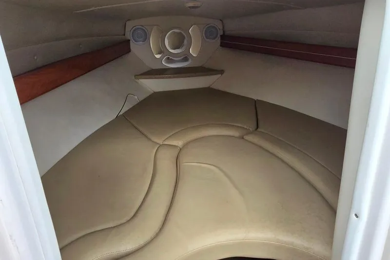 Slide: The Image of 2006 Rinker 246 Captiva Cuddy cabin interior with beige seating and wood accents. - 9