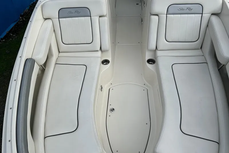 Slide: The Image of 2010 Sea Ray 260 Sundeck interior with white cushioned seating and cup holders. - 12