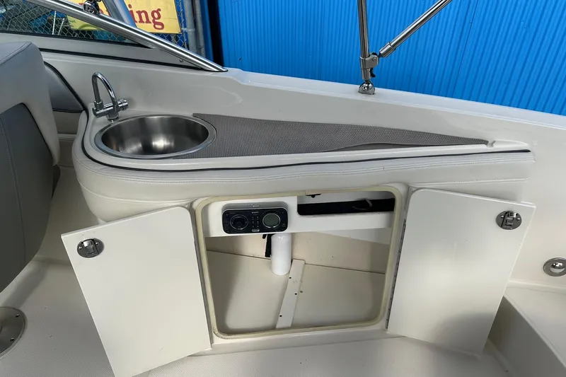 Slide: The Image of 2010 Sea Ray 260 Sundeck interior with sink and storage cabinet. - 19