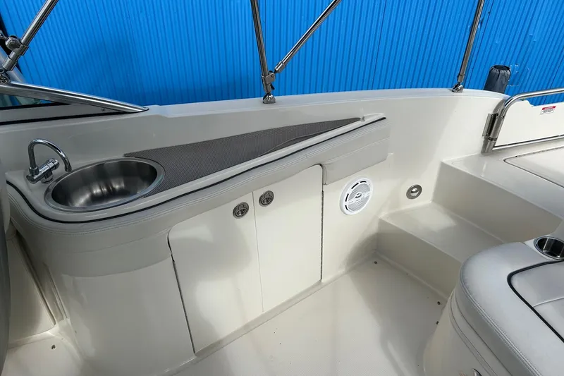Slide: The Image of 2010 Sea Ray 260 Sundeck interior with sink and storage, featuring sleek design elements. - 20