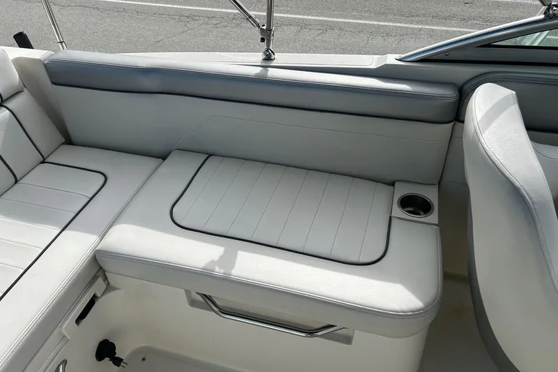 Slide: The Image of 2010 Sea Ray 260 Sundeck interior seating with cup holder, featuring sleek white upholstery. - 21