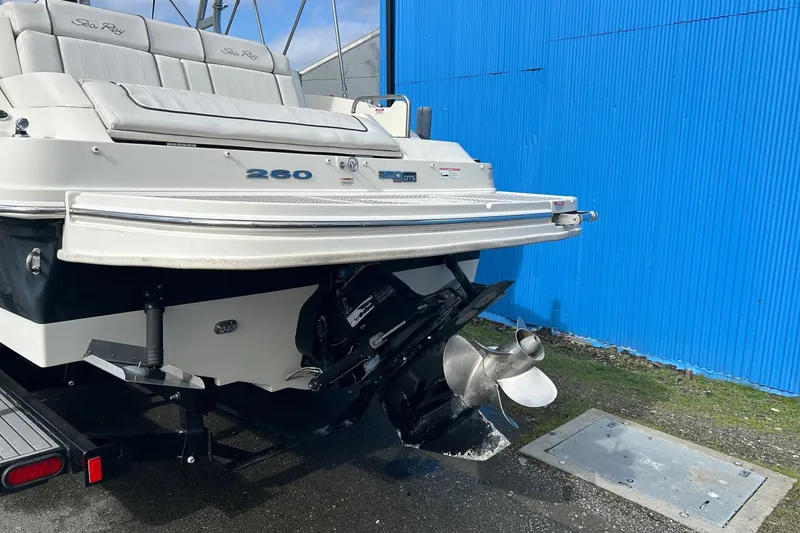 Slide: The Image of 2010 Sea Ray 260 Sundeck boat rear view with propeller, parked near blue wall. - 4