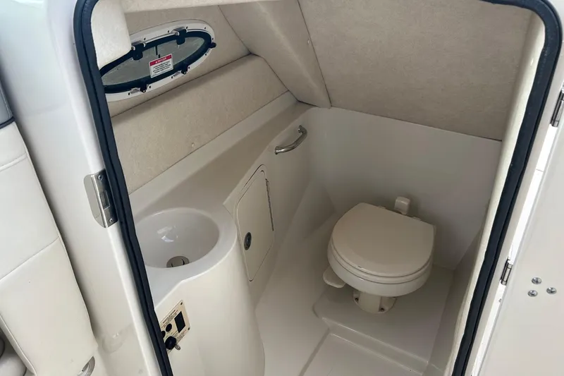 Slide: The Image of 2010 Sea Ray 260 Sundeck boat interior with compact bathroom and toilet. - 7