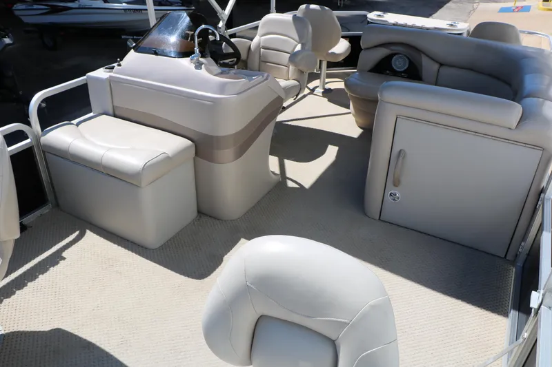 Slide: The Image of 2012 Starcraft Stardeck 206 4-PT boat interior with beige seating and steering console. - 19