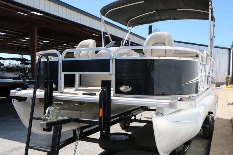 Slide: The Image of 2012 Starcraft Stardeck 206 4-PT pontoon boat on trailer, parked in storage facility. - 4
