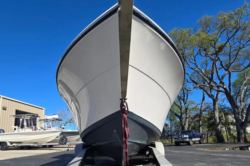 Slide: The Image of 2022 Cobia 237 Center Console boat on trailer, clear blue sky background. - 10