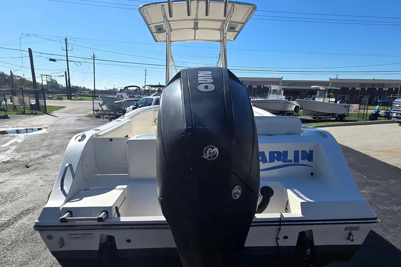Slide: The Image of 2022 Cobia 237 Center Console boat with powerful outboard motor, parked outdoors. - 5