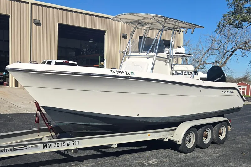 Slide: The Image of 2022 Cobia 237 Center Console boat on a trailer outside a warehouse. - 8