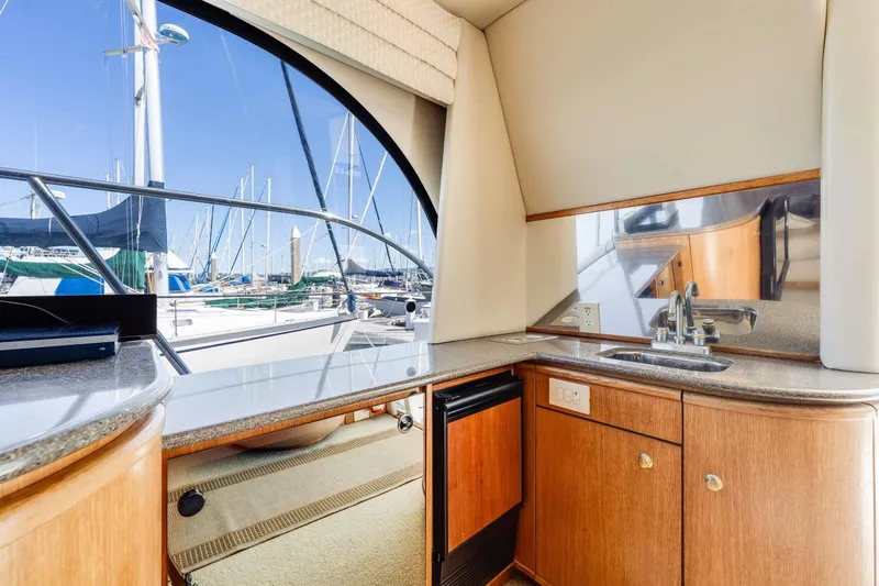 Slide: The Image of Interior of 1998 Bayliner 5788 Pilot House Motoryacht with kitchenette and marina view. - 100