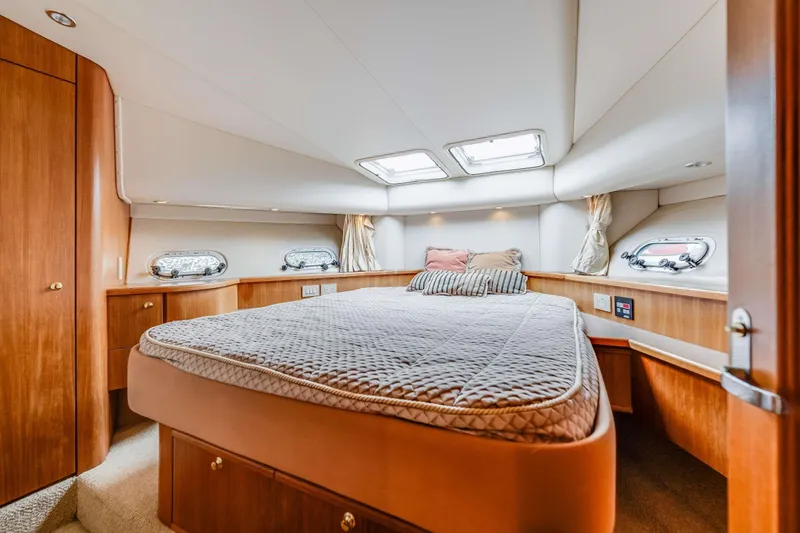 Slide: The Image of Luxurious bedroom in 1998 Bayliner 5788 Pilot House Motoryacht with elegant wood finishes. - 108